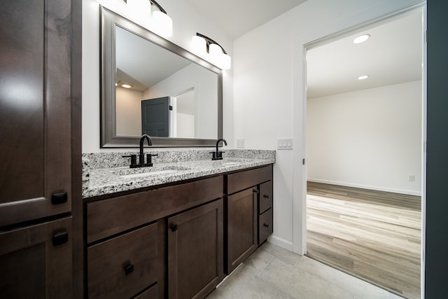 6522 Ellinwood Dr, White Lake, MI 48383 - bathroom featuring tile patterned floors, double vanity, baseboards, and a sink