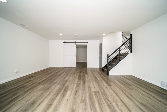 6522 Ellinwood Dr, White Lake, MI 48383 - unfurnished living room with visible vents, baseboards, a barn door, stairway, and wood finished floors