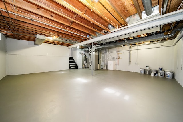 6522 Ellinwood Dr, White Lake, MI 48383 - unfinished basement featuring water heater, stairway, heating unit, and washer / dryer