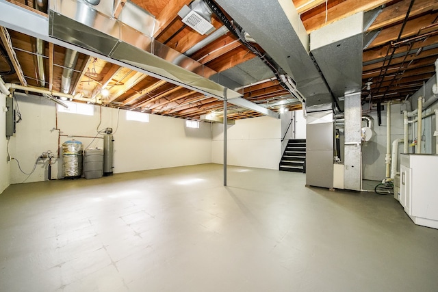 6522 Ellinwood Dr, White Lake, MI 48383 - below grade area featuring stairway, visible vents, and heating unit