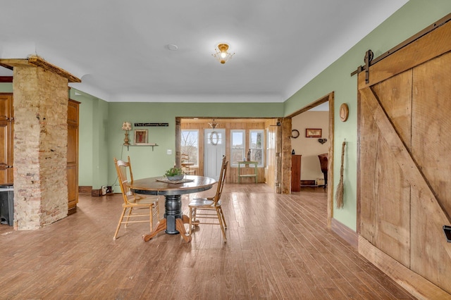 6357 Baldwin Rd, Swartz Creek, MI 48473 - dining space with baseboards, a barn door, and wood finished floors