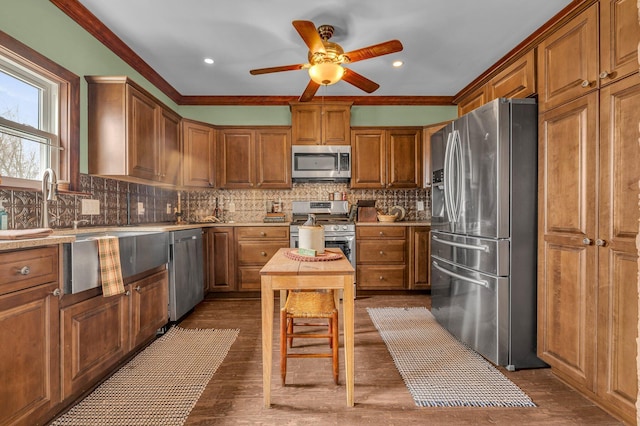 6357 Baldwin Rd, Swartz Creek, MI 48473 - kitchen featuring backsplash, brown cabinetry, appliances with stainless steel finishes, and a ceiling fan