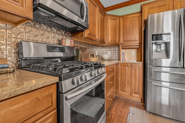 6357 Baldwin Rd, Swartz Creek, MI 48473 - kitchen with dark wood-type flooring, brown cabinetry, light stone counters, and appliances with stainless steel finishes