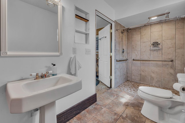 6357 Baldwin Rd, Swartz Creek, MI 48473 - bathroom featuring tiled shower, built in shelves, a sink, and toilet