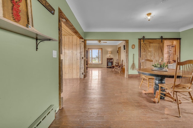 6357 Baldwin Rd, Swartz Creek, MI 48473 - dining room featuring a barn door, baseboard heating, and wood finished floors