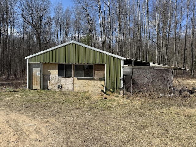 view of outbuilding with a wooded view and an outdoor structure