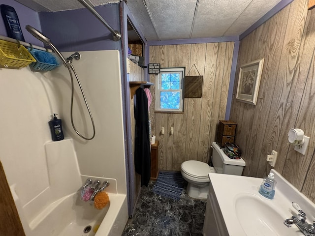 bathroom with wood walls, toilet, vanity, and shower / washtub combination