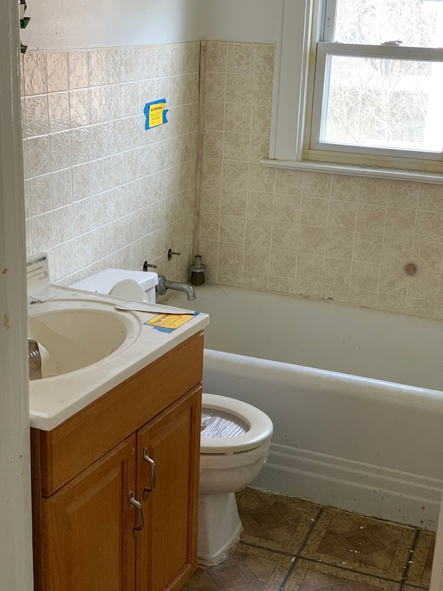 full bath with a tub to relax in, vanity, and toilet