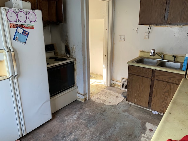 kitchen featuring visible vents, a sink, light countertops, white appliances, and concrete flooring