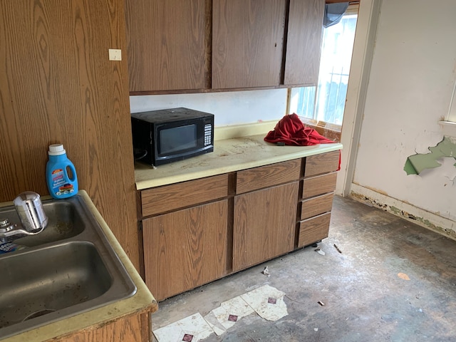 kitchen with a sink, light countertops, and black microwave