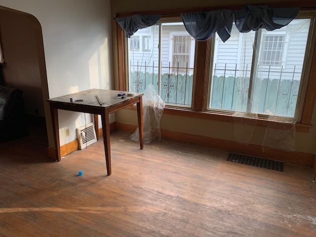 unfurnished dining area with wood finished floors, baseboards, and visible vents
