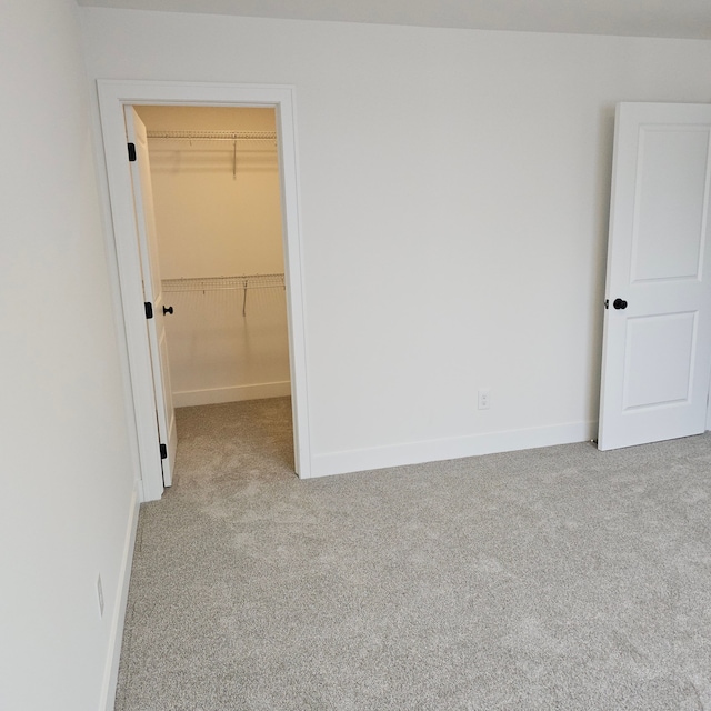 18468 Stallmann Dr, Macomb, MI 48042 - unfurnished bedroom featuring carpet, a walk in closet, baseboards, and a closet