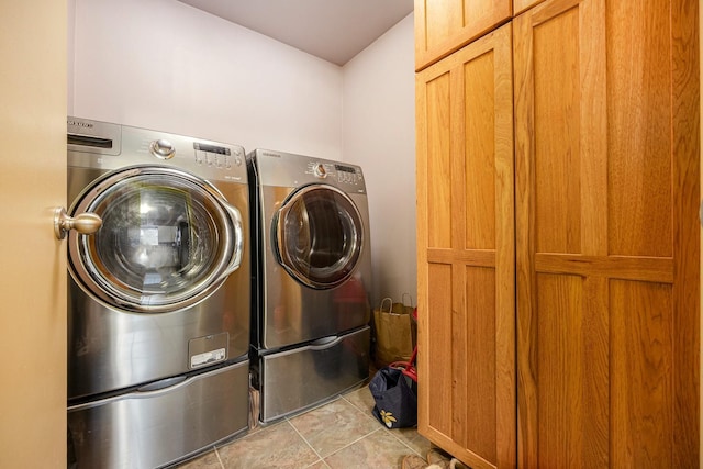 laundry room featuring tile patterned flooring, separate washer and dryer, and cabinet space