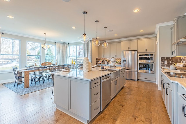 kitchen with light wood-style floors, gray cabinets, a sink, and appliances with stainless steel finishes