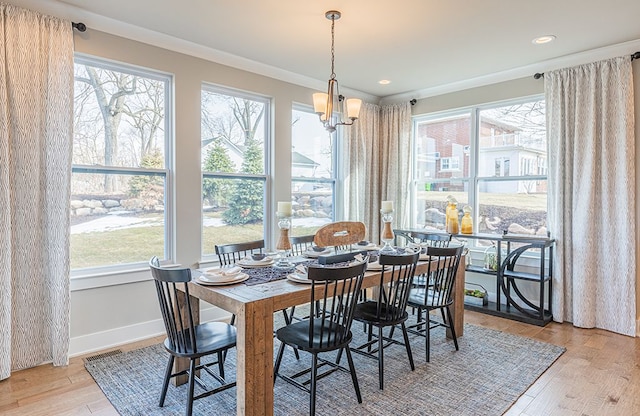dining room featuring baseboards, light wood-type flooring, an inviting chandelier, ornamental molding, and recessed lighting