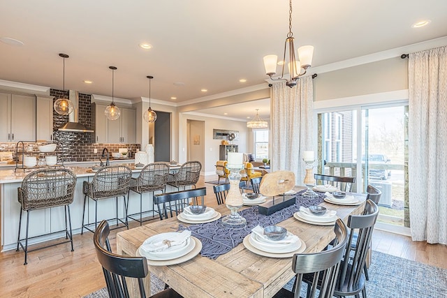 dining space featuring an inviting chandelier, recessed lighting, light wood-style flooring, and crown molding