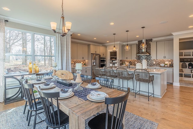 dining room with crown molding, light wood-style flooring, and recessed lighting