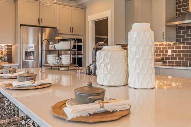 interior space with stainless steel appliances, light countertops, and backsplash