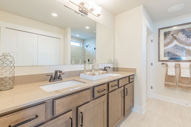 bathroom featuring a sink, a shower stall, double vanity, and recessed lighting