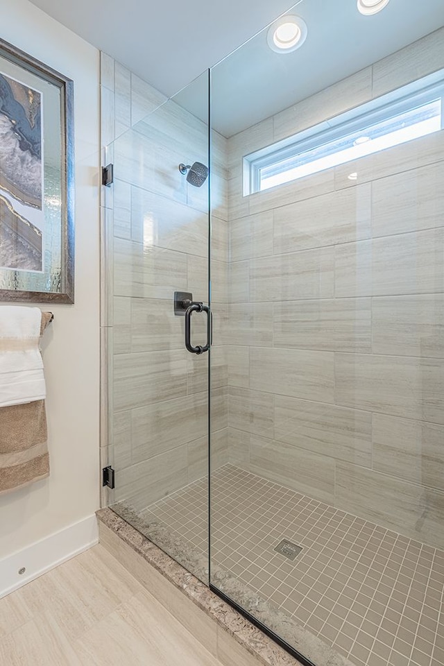 full bathroom with baseboards and a shower stall