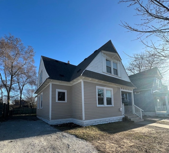 view of side of home featuring roof with shingles