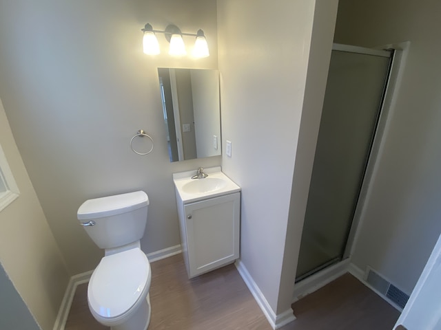 full bathroom with a shower stall, wood finished floors, visible vents, toilet, and vanity