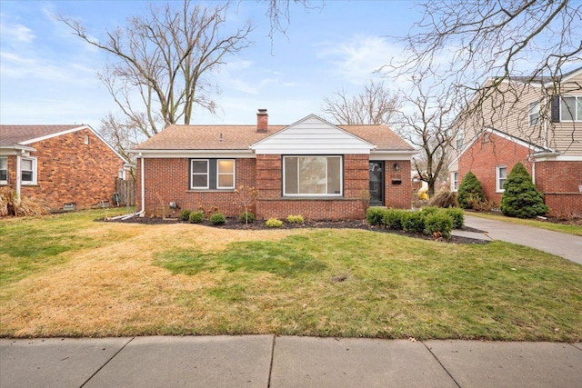 view of front of property with a front yard, brick siding, and a chimney