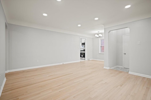 interior space with light wood-type flooring, a notable chandelier, baseboards, and recessed lighting