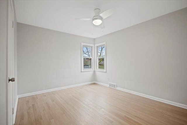 spare room featuring light wood-style floors, baseboards, visible vents, and ceiling fan