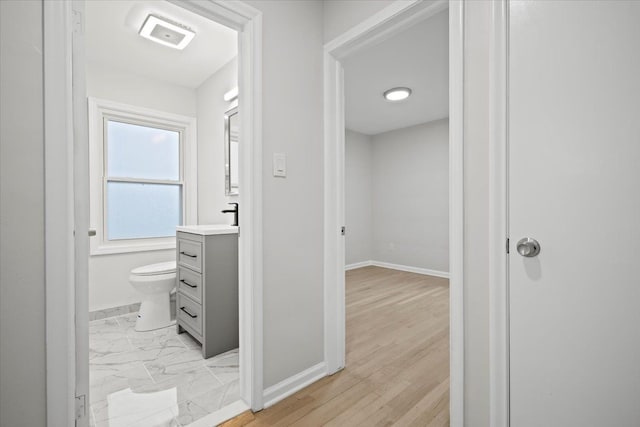 corridor featuring a sink, visible vents, and baseboards