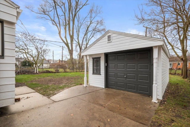 detached garage featuring fence and driveway