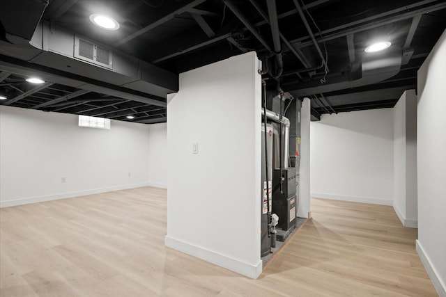 below grade area featuring visible vents, baseboards, and wood finished floors