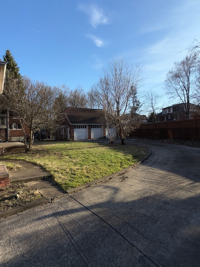 19411 Woodston Rd, Detroit, MI 48203 - ranch-style house featuring a front yard, an attached garage, fence, and driveway