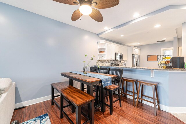 dining room featuring a ceiling fan, visible vents, recessed lighting, baseboards, and dark wood-style floors