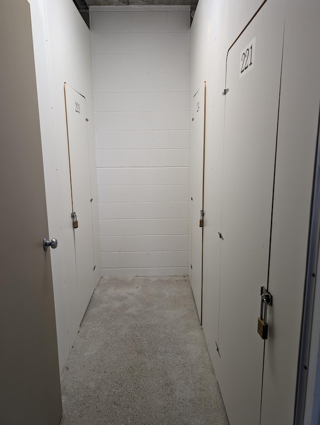 corridor featuring concrete flooring and concrete block wall