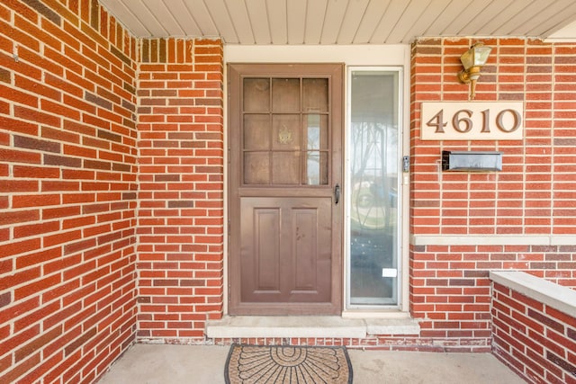 doorway to property featuring brick siding
