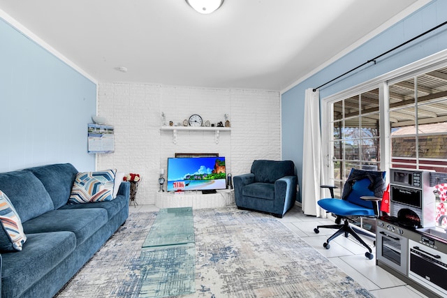 living area with brick wall, tile patterned floors, and a fireplace