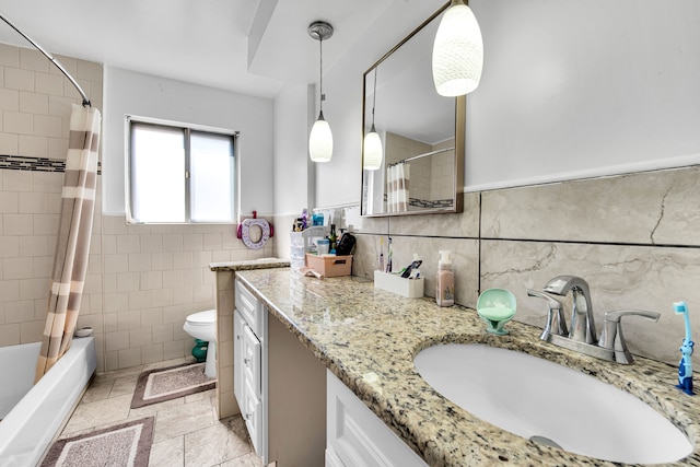 bathroom with shower / bathtub combination with curtain, vanity, toilet, wainscoting, and tile walls