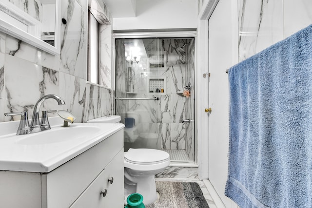 full bath with vanity, marble finish floor, toilet, and a marble finish shower