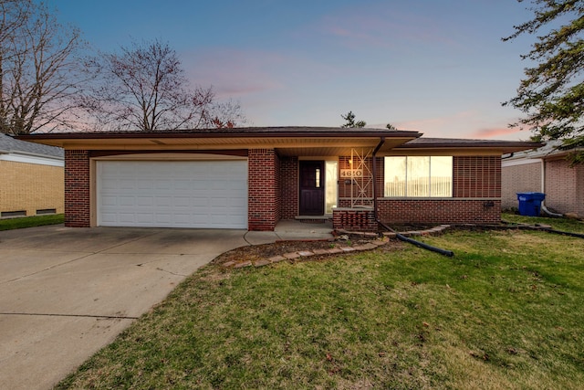 ranch-style home featuring concrete driveway, brick siding, a front lawn, and an attached garage