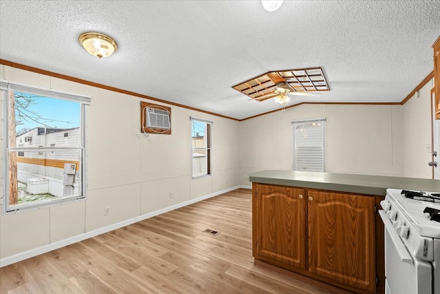22600 Middlebelt Rd Lot F-28, Farmington Hills, MI 48336 - kitchen with a wall mounted air conditioner, a peninsula, white gas stove, crown molding, and light wood-style flooring
