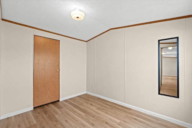 22600 Middlebelt Rd Lot F-28, Farmington Hills, MI 48336 - empty room featuring crown molding, vaulted ceiling, a textured ceiling, and light wood-style floors
