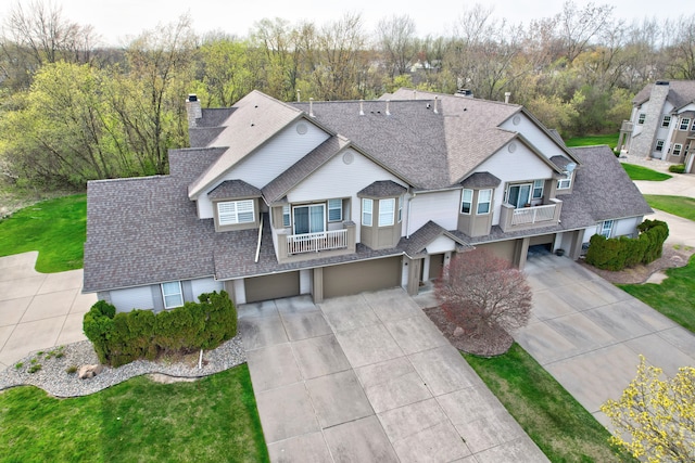 10025 Sunrise Dr, Grand Blanc, MI 48439 - view of front of property featuring concrete driveway, roof with shingles, a balcony, and an attached garage