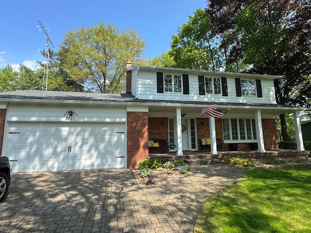 2126 Holly Tree Dr, Davison, MI 48423 - view of front of house with brick siding, a porch, a chimney, an attached garage, and driveway