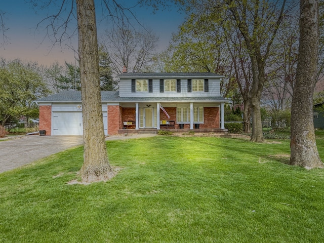 2126 Holly Tree Dr, Davison, MI 48423 - traditional home featuring asphalt driveway, an attached garage, brick siding, and a porch