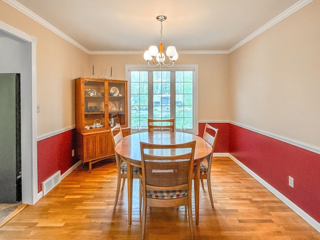 2126 Holly Tree Dr, Davison, MI 48423 - dining space featuring light wood-style flooring, a chandelier, crown molding, and baseboards