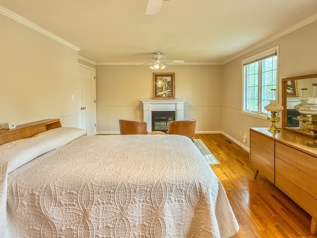 2126 Holly Tree Dr, Davison, MI 48423 - bedroom with light wood-type flooring, a glass covered fireplace, baseboards, crown molding, and ceiling fan