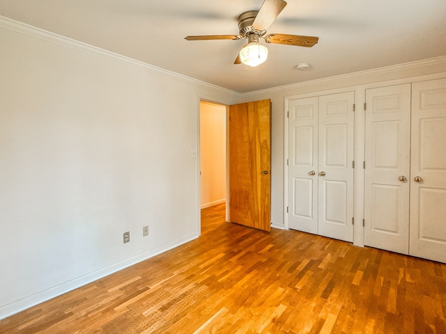 2126 Holly Tree Dr, Davison, MI 48423 - unfurnished bedroom featuring two closets, wood finished floors, crown molding, baseboards, and a ceiling fan