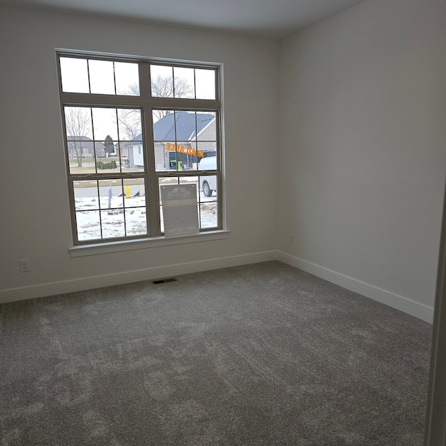 carpeted empty room with baseboards and visible vents