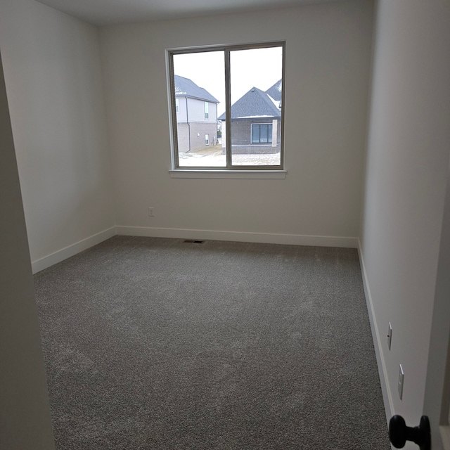 empty room featuring baseboards, carpet, and visible vents
